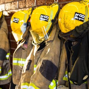 Firefighter Coats & Helmets Hanging in a Row