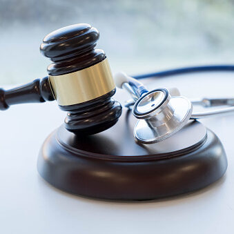 Judge's gavel with stethoscope laying next to it