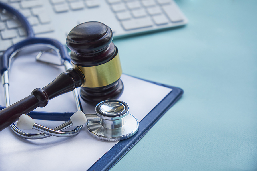 Gavel, stethoscope, and laptop keyboard