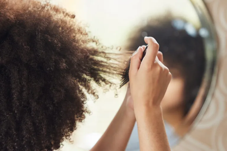 Woman combs natural hairstyle