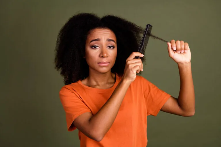 Woman combs unruly natural hair style